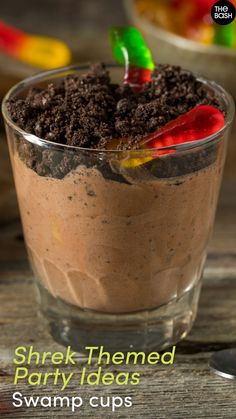 there is a dessert in a glass with chocolate and candy toppings on the top