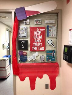 an office cubicle decorated with red and white paint on the wall, bulletin board attached to the door