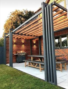 an outdoor patio with benches and grilling area