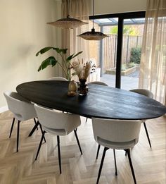 a dining room table with white chairs around it