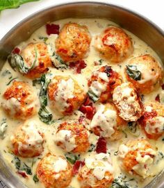 a pan filled with meatballs covered in cheese and spinach