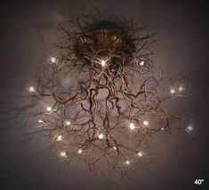 a light fixture with branches and lights hanging from it