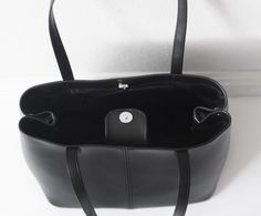 "This simple tote features black vegan (fake) leather, magnet top closure and internal pockets. Details: -Dimensions: 12\" length (top to bottom), 10\" bottom width, 7\" depth, 10\" X 7\" base (bottom) -Each shoulder strap measures approximately 23\" full length -Black vegan (fake) leather -Fabric interior lining (solid black) - color can be customized -Internal pockets: 1 slip pocket, 1 zippered pocket -Magnet top closure Because each bag is made by hand, the measurement is approximate and may Everyday Satchel With Magnetic Closure And Double Handle, Everyday Double Handle Satchel With Magnetic Closure, Chic Large Capacity Shoulder Bag, Chic Medium Shoulder Bag With Large Capacity, Everyday Satchel Tote With Magnetic Closure, Business Tote Satchel With Magnetic Closure, Everyday Satchel With Magnetic Closure And Tote Shape, Everyday Satchel With Magnetic Closure, Black Tote Satchel With Magnetic Closure