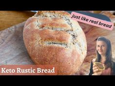 a woman holding a piece of bread next to a loaf of bread on a cutting board