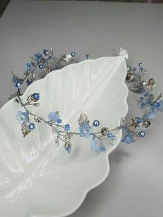 a white bowl with blue flowers and leaves on it