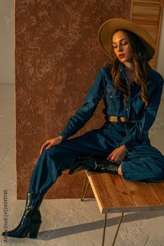 Stock Image: Full-length fashion portrait of young confident woman, model, wearing denim jumpsuit, beige wide brim hat, trendy cowboy ankle boots Western Jumpsuit With Cowboy Boots, Cowboys Boots Jeans, Looks Total Jeans, Cowboy Ankle Boots, Earthy Style, Cowboy Girl, Bohemian Lifestyle, Confident Woman, Fashion Portrait