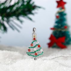 Celebrate the season any time of year with this shimmering Christmas tree pendant. Beautifully handcrafted in sterling silver, this pendant features an evergreen - decorated with alluring enhanced green stones, red stones, and white stones - that features a gold-tone silver star on the top. A festive look that will go with any outfit, this Christmas tree necklace will be a lovely gift for her this season!Carat Weight: 0.89 ctStone Size: 2.4,1,1.2 mmStone Type: Jeulia® StoneNumber of Stones: 44 S Green Christmas Jewelry For Festive Occasion, Christmas Holiday Green Jewelry, Green Christmas Holiday Jewelry, Green Sparkling Stones Necklace For Gift, Silver Christmas Pendant Necklace, Christmas Sterling Silver Jewelry, Holiday Sterling Silver Necklaces, Silver Holiday Jewelry, Holiday Sterling Silver Necklaces In Silver