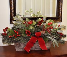 a wooden box filled with holly and red berries