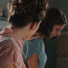 two women standing in front of a mirror