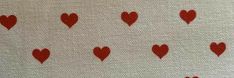 red hearts are arranged on white fabric