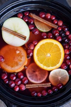 cranberries, apples, oranges and cinnamon sticks in a slow cooker