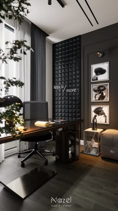 an office with black and white walls, wooden floors and a plant in the corner