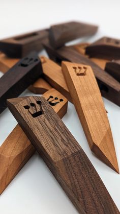 wooden pegs with faces on them sitting next to other woodworking tools and knives