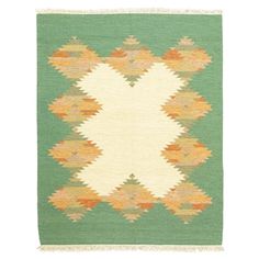 a green and white rug with an orange design