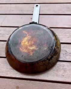 a wooden table topped with a metal object on top of it's side,