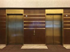 an empty room with two elevators and wooden paneled walls on either side of the doors