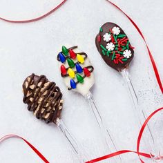 three chocolate covered candy lollipops with decorations on them