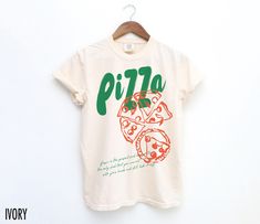 Satisfy your style cravings with this vintage-inspired Pizza tee! Featuring a bold pizza graphic this shirt adds a slice of retro fun to any casual look. The text at the bottom reads, " Pizza is the perfect food because it is the only food that you can eat with your hands and still look classy."  We use professional quality DGT printing on all our apparel. Direct-to-garment, or DTG, is a high quality printing method that sprays ink directly onto the garment so there is no peeling or cracking. Th Retro Slogan Crew Neck Shirt, Retro Slogan Shirt With Crew Neck, Unisex Retro T-shirt With Text Print, Retro Crew Neck Shirt With Slogan, Vintage Text Print Unisex Tops, Vintage Unisex Text Print Tops, Unisex Vintage Text Print Tops, Unisex Vintage Tops With Text Print, Vintage Crew Neck Shirt With Graphic Print