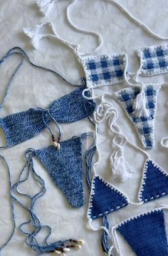 several pieces of blue and white crocheted clothing laid out on top of each other