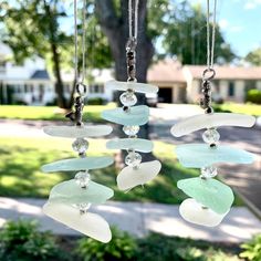 a wind chime hanging in front of a tree with lots of glass pieces on it