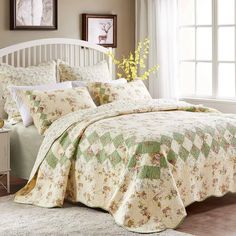 a bedroom with a white headboard and bed covered in floral bedspreads