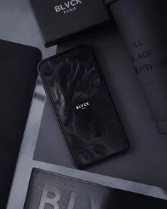 a black phone sitting on top of a table next to some papers and other items