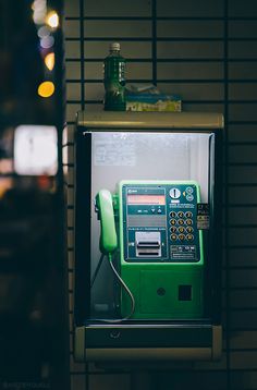 an old fashioned green gas pump in a public restroom with lights on the wall behind it