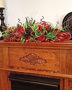 a wooden fireplace mantel with red and green decorations