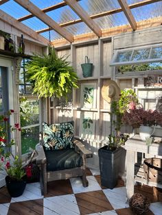 an outdoor room with potted plants on the windowsill and a checkered floor