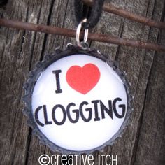 a bottle cap with the word i love clogging on it hanging from a cord