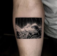 a man's arm with a black and white tattoo on it, depicting a woman sleeping in the rain