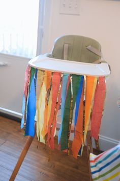 a baby highchair with colorful streamers hanging from it