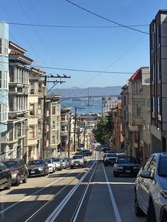 cars are driving down the street in front of some buildings and an over pass bridge