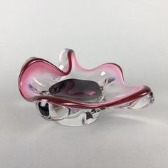 a pink glass bowl sitting on top of a white table