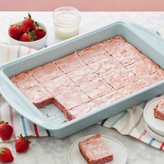 a cake pan filled with strawberry shortbreads on top of a table next to strawberries