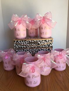 pink candles with bows are sitting on a table next to two boxes that say one place