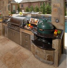 an outdoor kitchen with grill, sink and counter space next to the swimming pool area