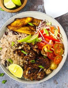 a bowl filled with rice, meat and veggies on top of a table