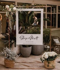 a sign that says sage and north sitting on top of a table with potted plants