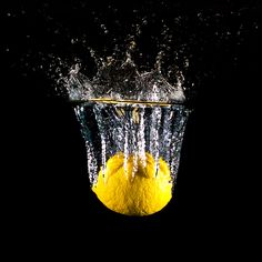 an orange being dropped into the water