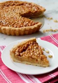 a slice of pecan pie on a plate next to the rest of the pie