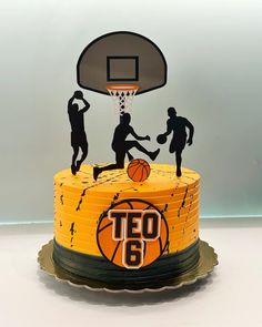 a birthday cake decorated with basketballs and people playing the game on top of it