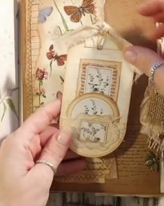 a woman is working on an altered piece of paper with flowers and butterflies in it