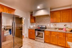 a kitchen with wooden cabinets and stainless steel appliances