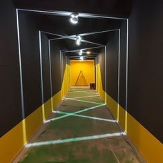 an empty hallway with yellow and black walls