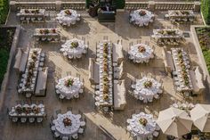 an aerial view of tables and chairs set up for a formal function with umbrellas