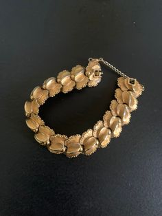 This elegant D'Orlan bracelet features articulated gold-colored links with gold-tone metal details. 7.5 inches in length with a folding clasp. Signed D'Orlan on the back with a serial number. In very good vintage condition D'Orlan was founded in 1957 in Toronto by Maurice Bradden, former student of Marcel Boucher. The manufacturing of D'Orlan jewelry is such that it was sold in department stores and high-end boutiques. Vintage Yellow Gold Link Bracelets, Vintage Link Gold Bracelet For Formal Occasions, Vintage Gold Link Bracelet For Formal Occasions, Vintage Gold-tone Jubilee Bracelet, Vintage Yellow Gold Hinged Bracelet, Vintage Gold-tone Chain Bracelet For Formal Occasions, Vintage Jubilee Bracelet For Evening, Gold Costume Jewelry Bracelets For Evening, Vintage Gold Bracelet With Clasp