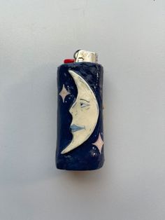 a blue lighter with a white moon and stars on the side, hanging from a hook