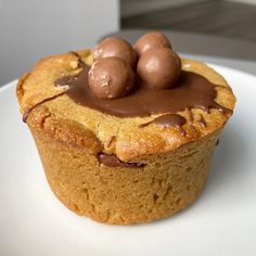 a close up of a cupcake on a plate with three chocolate balls in the middle