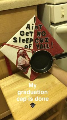 a graduation cap is sitting on top of a table with a black pan in front of it